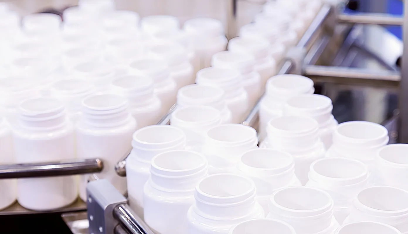 Conveyor belt with empty white bottles